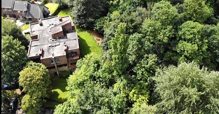 Aerial view of the apartment block with dense woodland alongside
