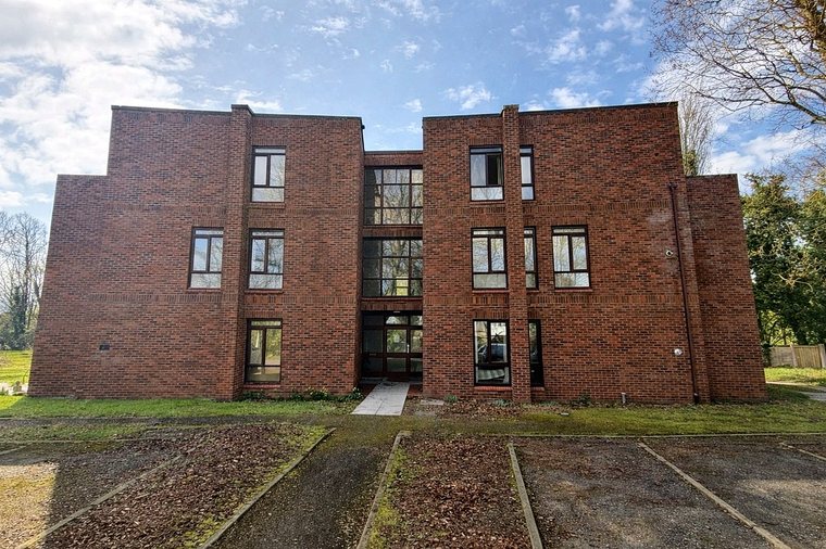 The front elevation of the apartment block with the glazed stairwell above the main entrance