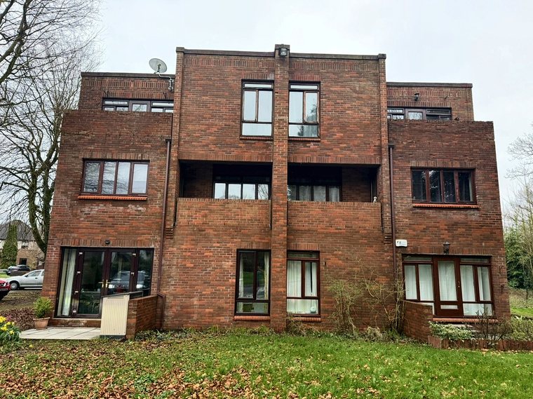The brick garden elevation of the apartment block with its balconies, facing the lawn